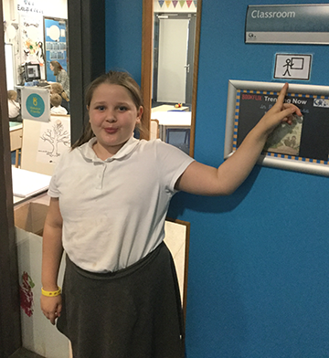 Young girl pointing at Makaton symbol for Classroom