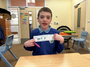 Young boy holding Makaton Symbols
